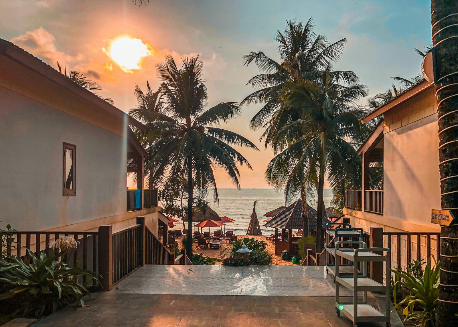 Beautiful sunset over palm-lined beach at Phu Quoc resort, Vietnam, capturing a serene and tropical atmosphere.